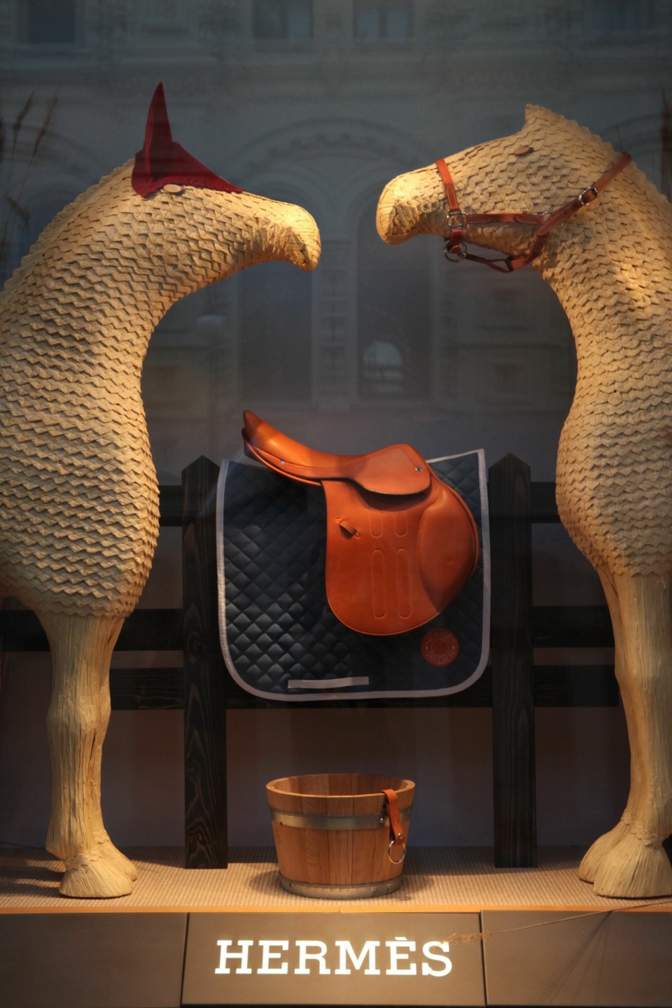 Immagine di una vetrina di Hermès, con due cavalli-manichino in esposizione con alcuni elementi di selleria